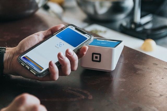 Une personne fait une transaction via un iPhone.